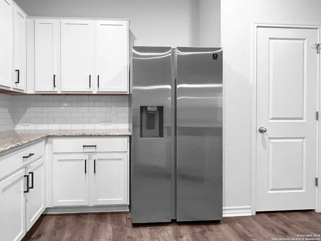 a kitchen with cabinets and a refrigerator