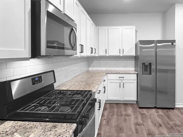 a kitchen with a stove a refrigerator and a sink