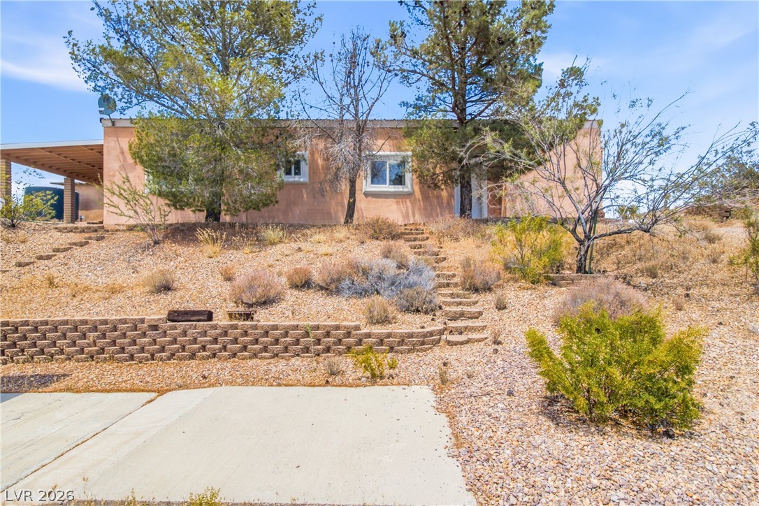 Rocking S Ranch Road Searchlight, NV 89046 - Photo 41 of 47 A tranquil desert landscape surrounds this inviting residence, featuring a covered patio and a winding stone pathway.