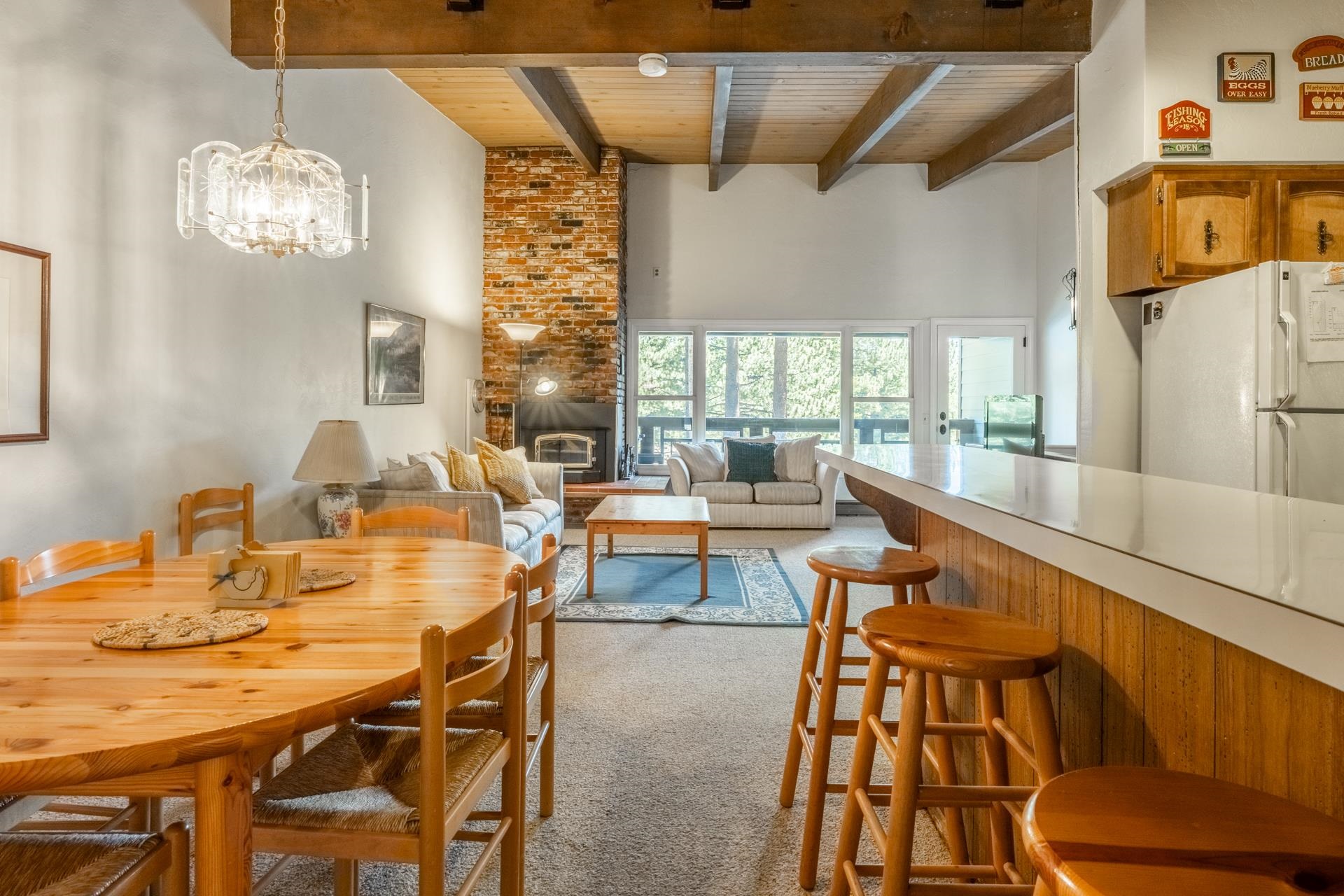 50 Hidden Valley Road, Unit 17 Mammoth Lakes, CA 93546 - Photo 11 of 40 Vaulted ceilings with exposed wood beams, brick fireplace, wood-finish flooring, and large windows