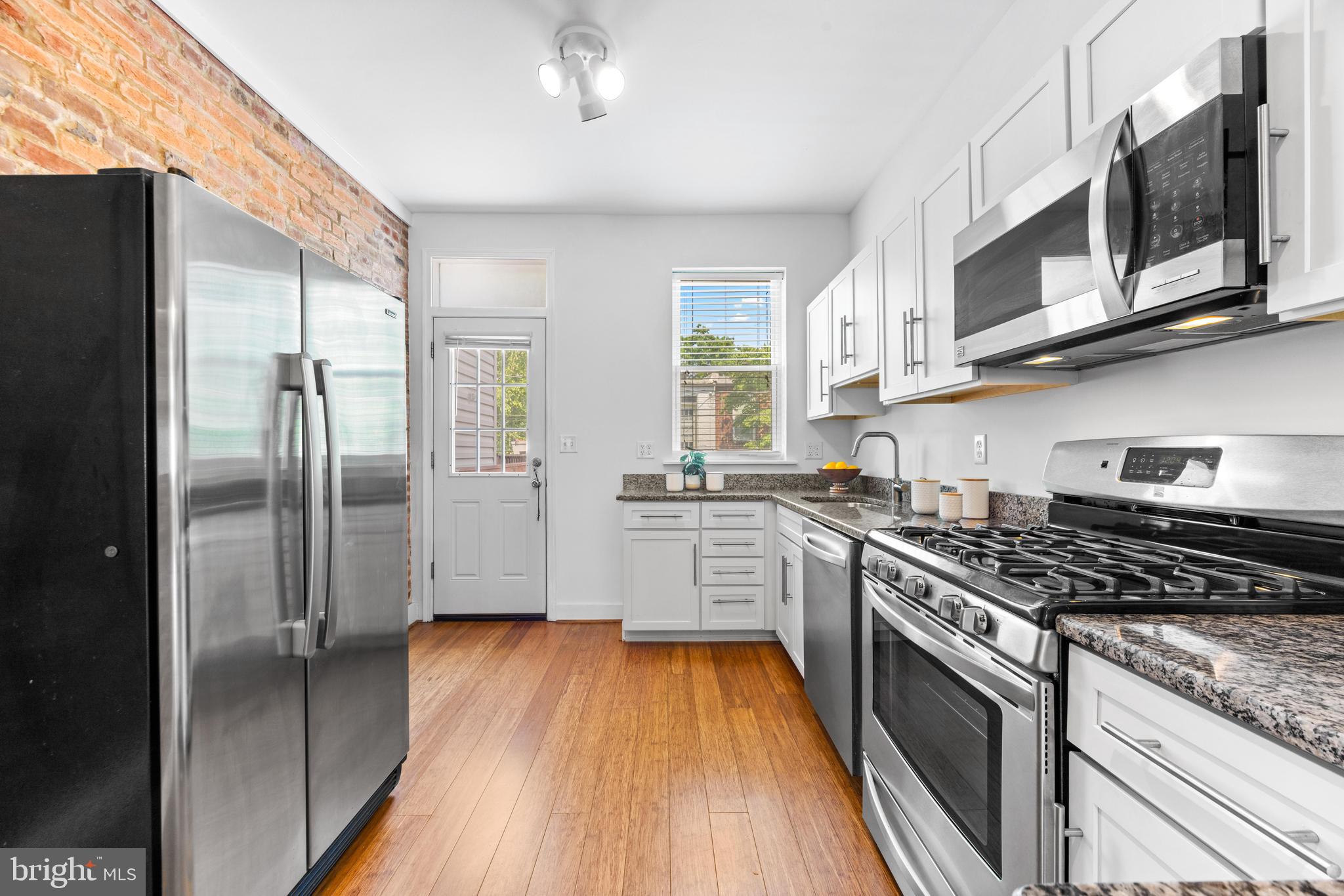3353 Beech Avenue Baltimore, MD 21211 - Photo 13 of 32 a kitchen with stainless steel appliances granite countertop a stove and a refrigerator