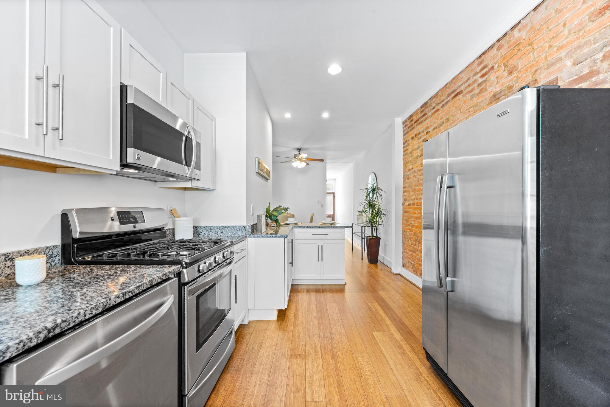 3353 Beech Avenue Baltimore, MD 21211 - Photo 16 of 32 a large kitchen with stainless steel appliances granite countertop a stove a sink and a refrigerator