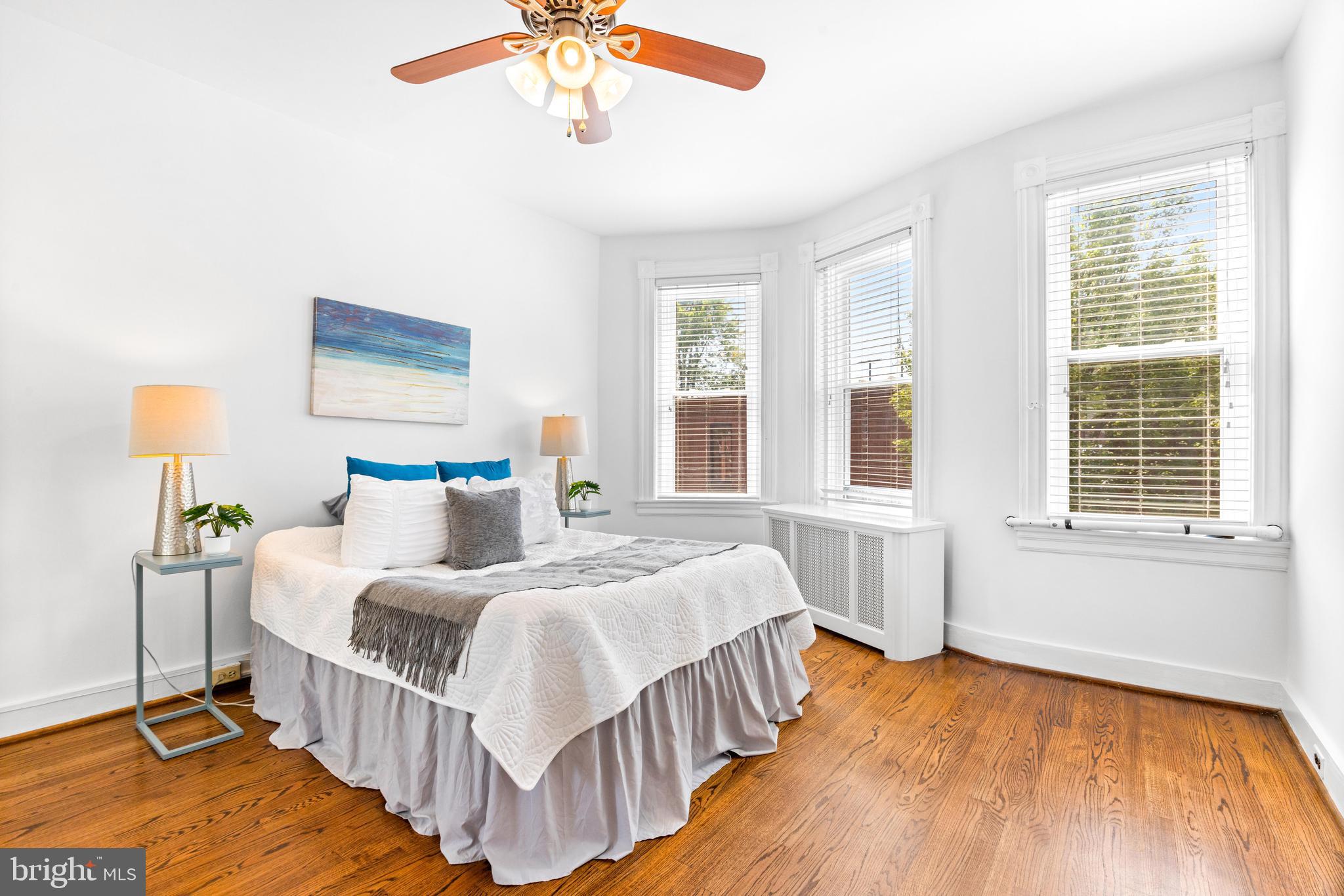 3353 Beech Avenue Baltimore, MD 21211 - Photo 19 of 32 a bedroom with a bed a chandelier and next to a window