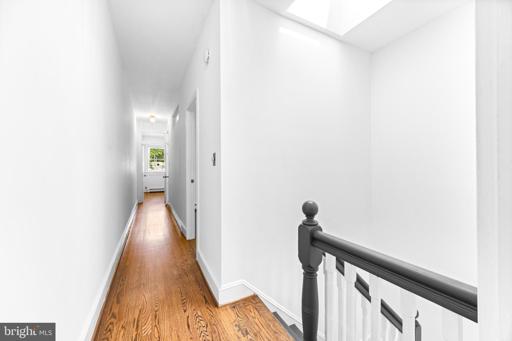 3353 Beech Avenue Baltimore, MD 21211 - Photo 21 of 32 a view of a hallway with wooden floor and stairs