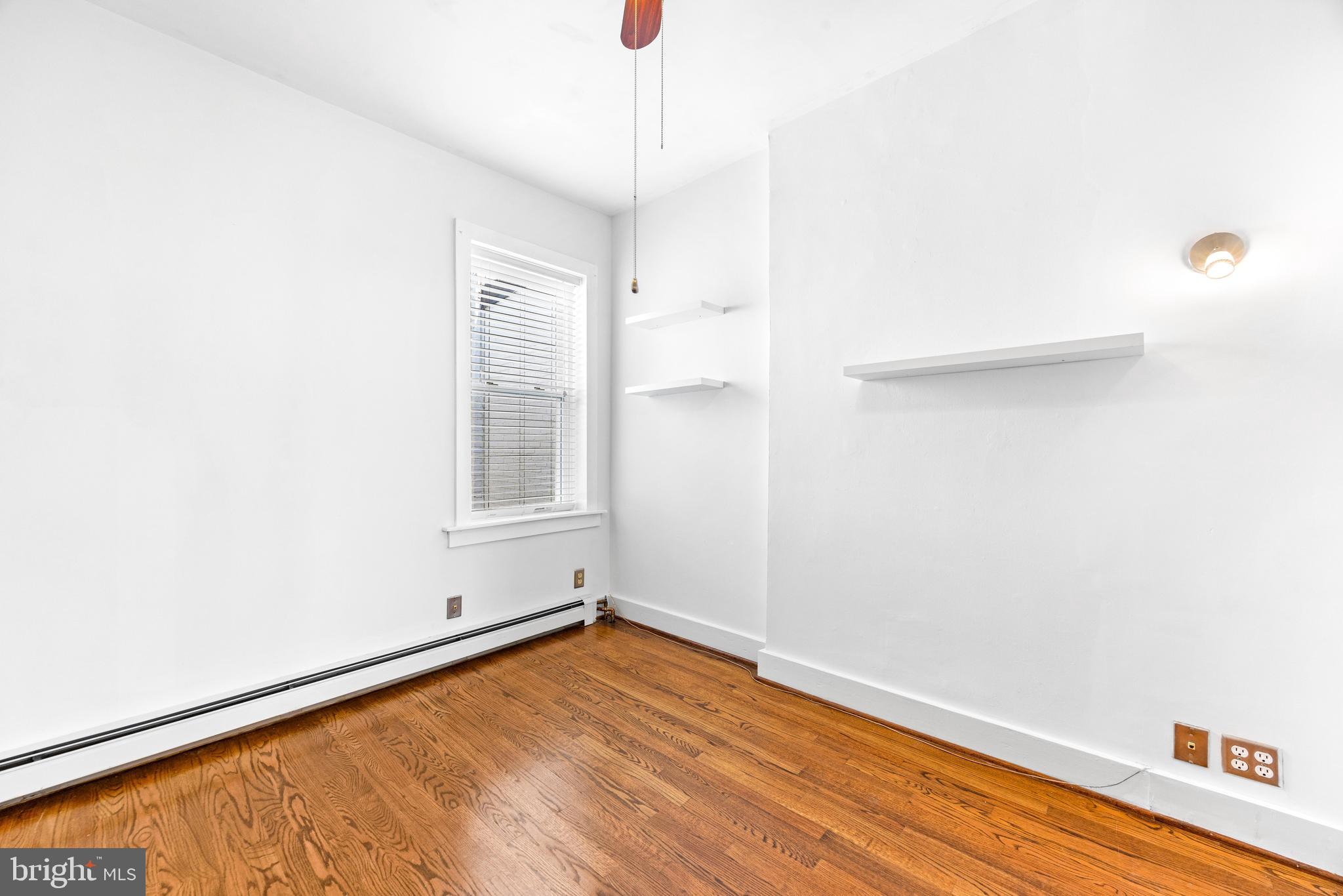 3353 Beech Avenue Baltimore, MD 21211 - Photo 25 of 32 a view of an empty room with wooden floor and a window
