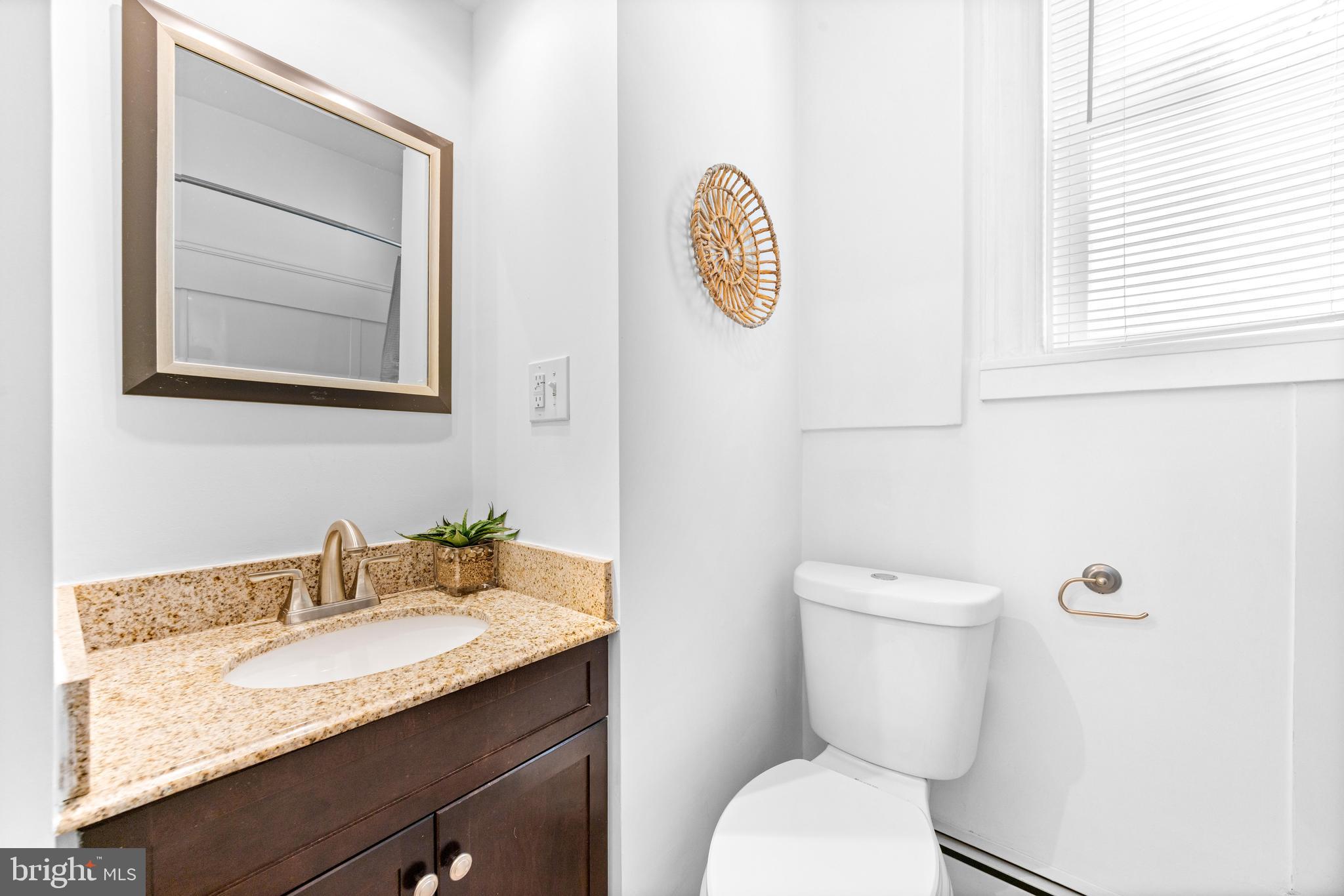 3353 Beech Avenue Baltimore, MD 21211 - Photo 27 of 32 a bathroom with a toilet a sink and mirror
