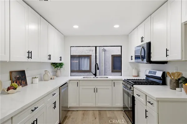 a kitchen with a sink stove and cabinets