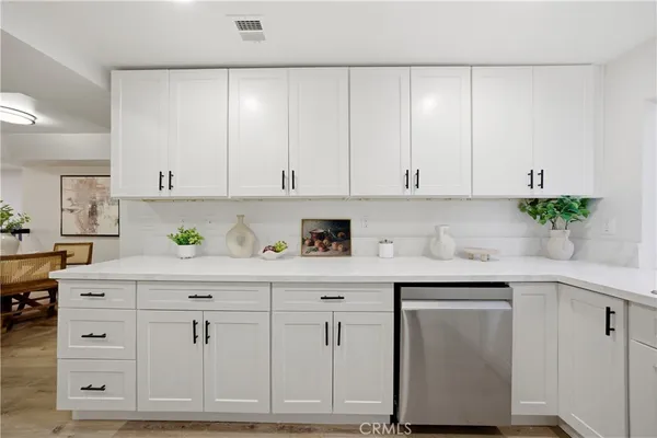 a kitchen with white cabinets and white appliances