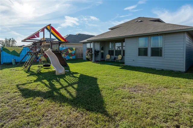 a view of a house with a backyard and a patio