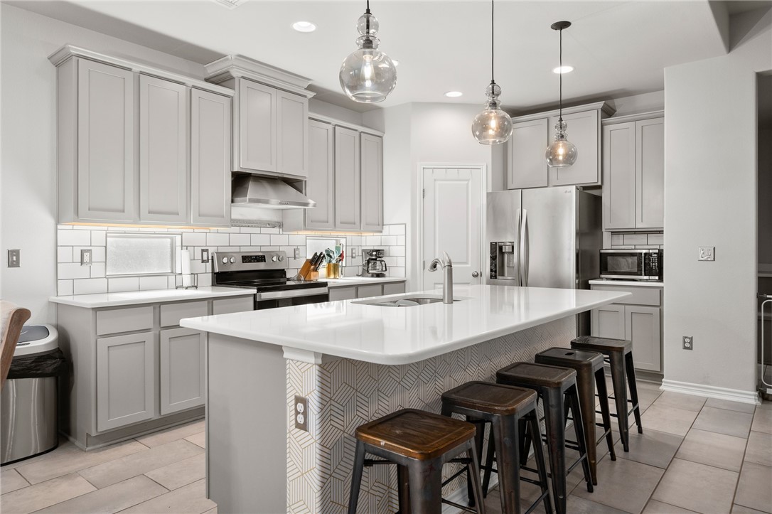 1031 Ocean Breeze Portland, TX 78374 - Photo 9 of 35 a kitchen with stainless steel appliances granite countertop a sink a stove a refrigerator and island with wooden floor