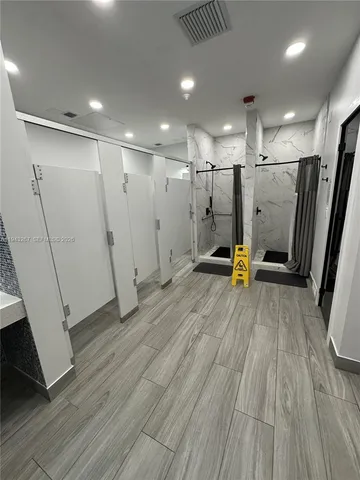 a view of an empty room with wooden floor and stairs