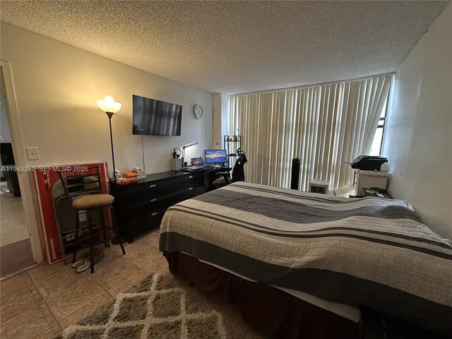 a spacious bedroom with a bed and a dresser in it