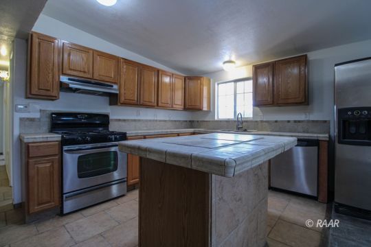 1645 Porter Street Ridgecrest, CA 93555 - Photo 11 of 35 a kitchen with granite countertop stainless steel appliances and wooden cabinets