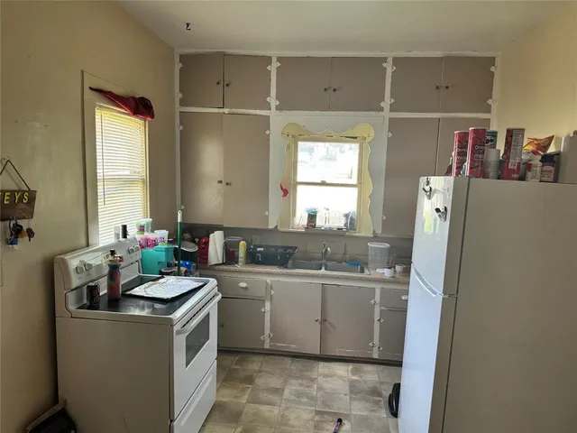 a room with a sink a window and a washer dryer