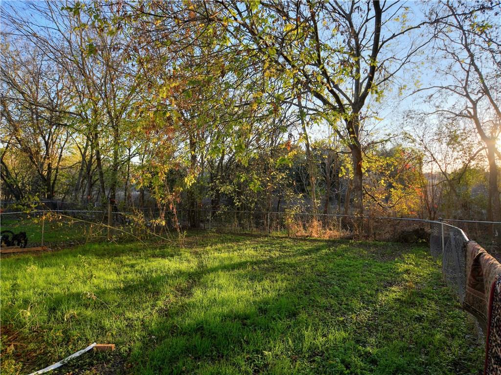 5401 Spring Meadow Road, Unit B Austin, TX 78744 - Photo 21 of 21 A verdant lawn provides a natural setting, bordered by a fence and mature trees.