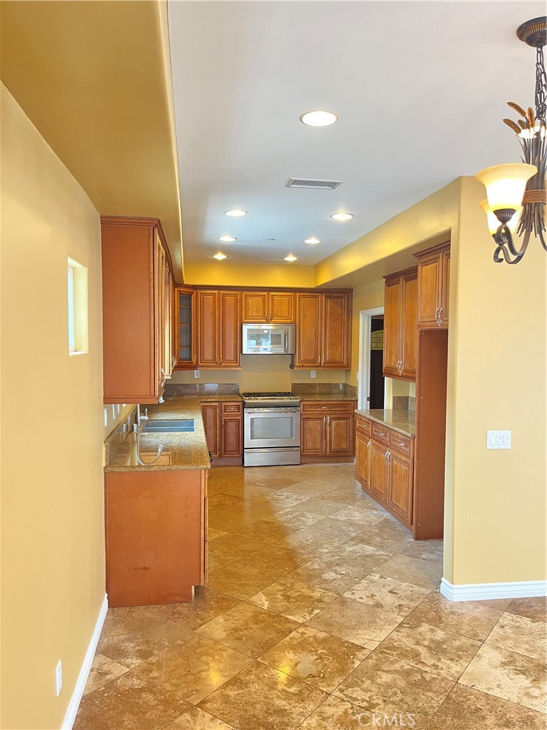 244 Avenida Granada, Unit B San Clemente, CA 92672 - Photo 5 of 19 a view of a kitchen with kitchen island a counter top space cabinets and appliances