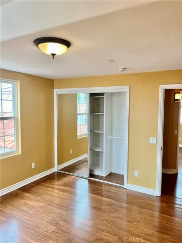 an empty room with wooden floor and a window