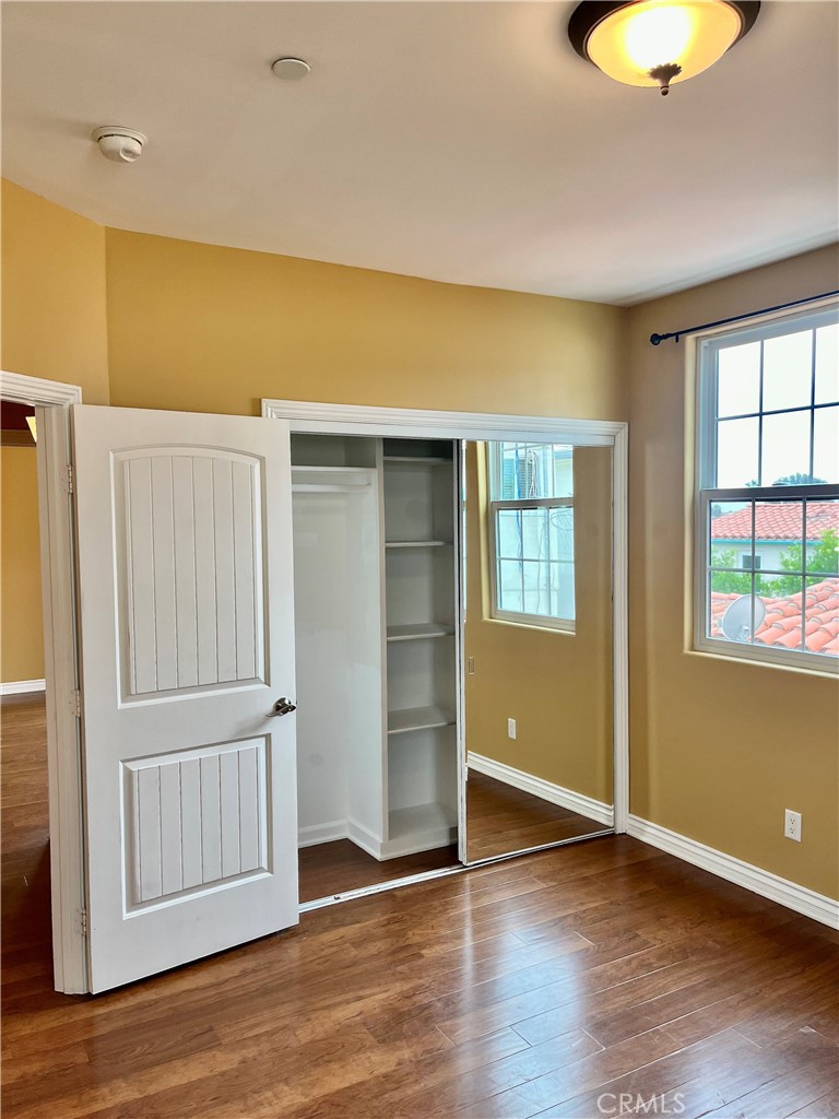 244 Avenida Granada, Unit B San Clemente, CA 92672 - Photo 9 of 19 an empty room with wooden floor and windows
