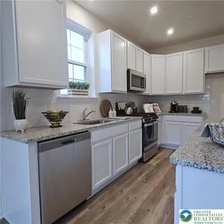a kitchen with granite countertop a sink stainless steel appliances and cabinets