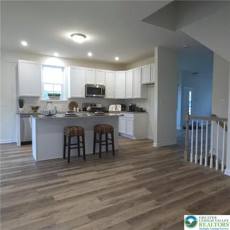 a kitchen with kitchen island granite countertop a sink and cabinets
