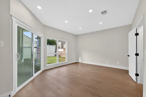 a spacious bedroom with a bed and glass door