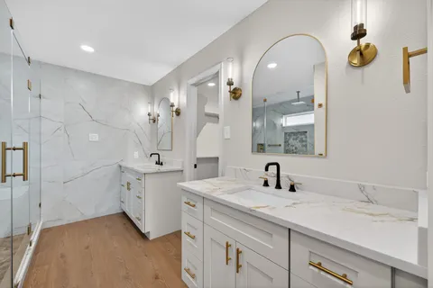 a spacious bathroom with a granite countertop sink mirror and bathtub