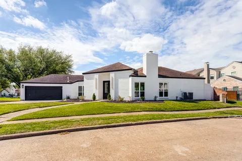 a view of a house with a big yard and large trees