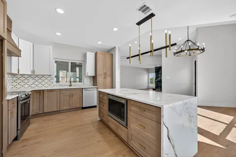 a kitchen with stainless steel appliances granite countertop a sink stove and refrigerator