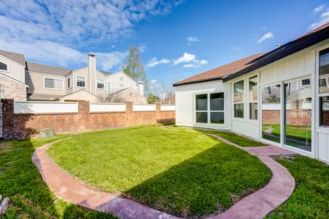 an aerial view of a house with a yard and pool table and chairs