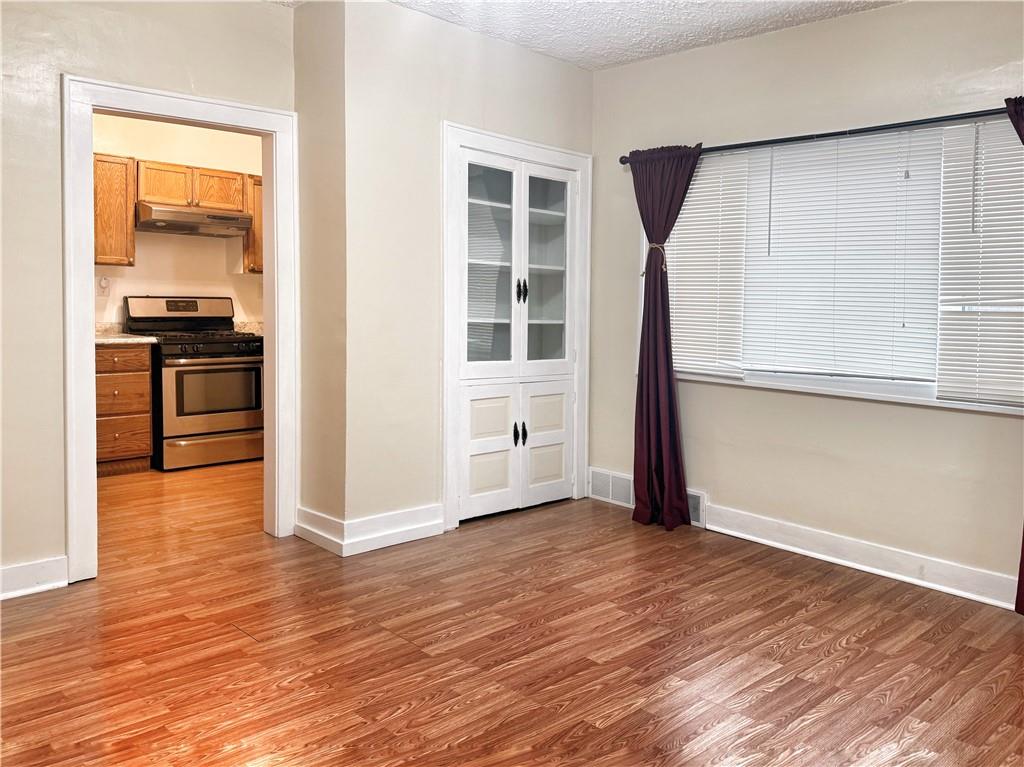 389 Webster Street Rochester, PA 15074 - Photo 7 of 24 an empty room with wooden floor and windows