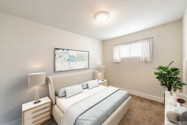 a bedroom with a bed and a potted plant