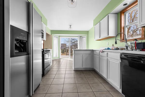 a kitchen with stainless steel appliances kitchen island granite countertop a refrigerator and a stove top oven