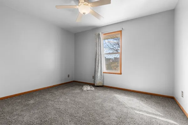 an empty room with a window and a fan