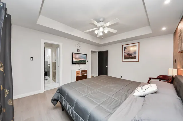 a bedroom with a large bed and a chandelier