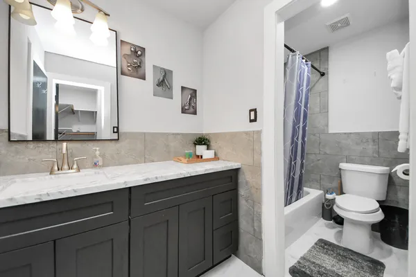 a bathroom with a granite countertop sink mirror and a toilet
