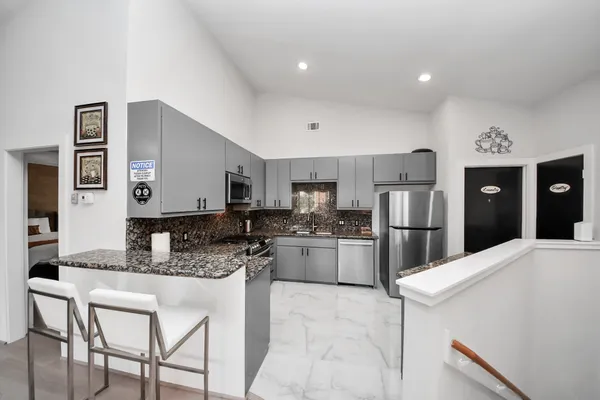 a kitchen with a refrigerator and a stove top oven