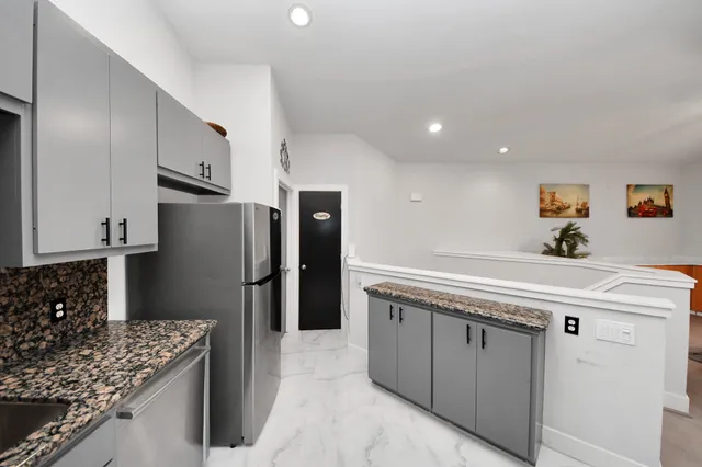 a kitchen with stainless steel appliances granite countertop a sink stove and refrigerator