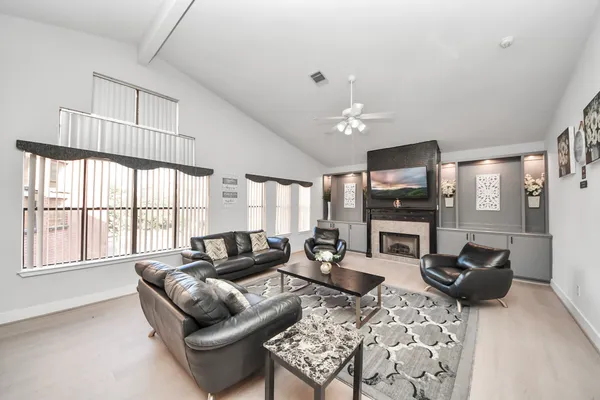 a living room with furniture a fireplace and a flat screen tv