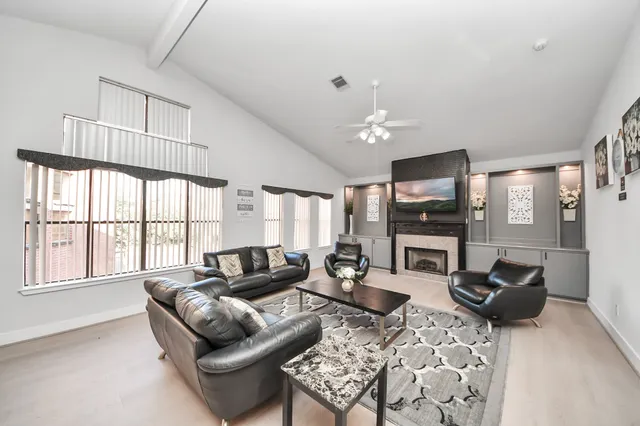 a living room with furniture a fireplace and a flat screen tv