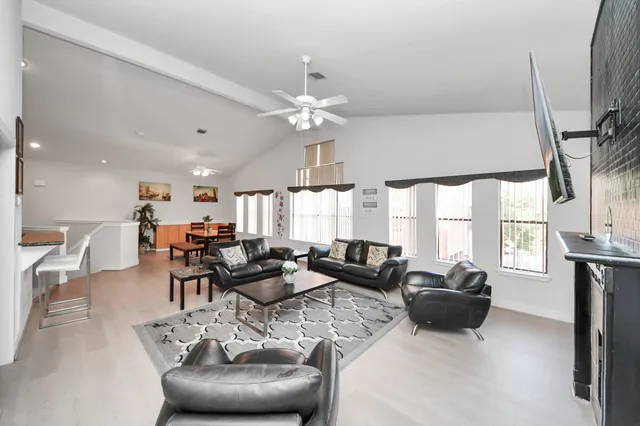 a living room with furniture a large window and a chandelier