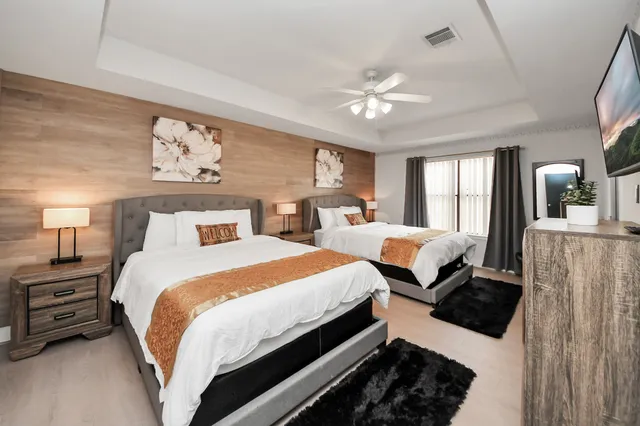 a bedroom with beds and a large mirror