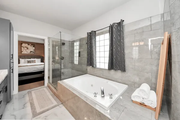 a bathroom with a tub sink and mirror