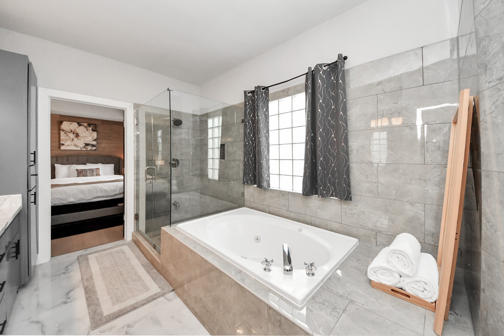 9715 Riddlewood Lane Houston, TX 77025 - Photo 33 of 43 Luxurious primary bathroom featuring a spacious glass-enclosed shower, elegant marble tiles, and a relaxing soaking tub. Perfect for unwinding in style.