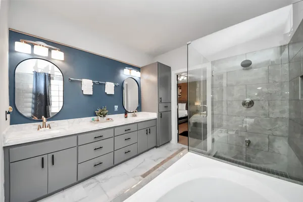 a spacious bathroom with a double vanity sink double mirror and shower
