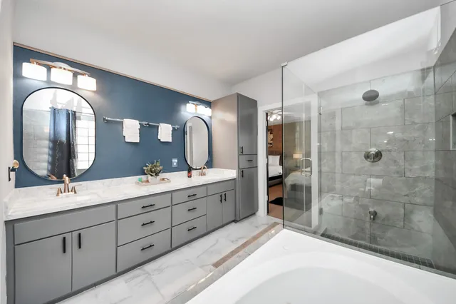 a spacious bathroom with a double vanity sink double mirror and shower