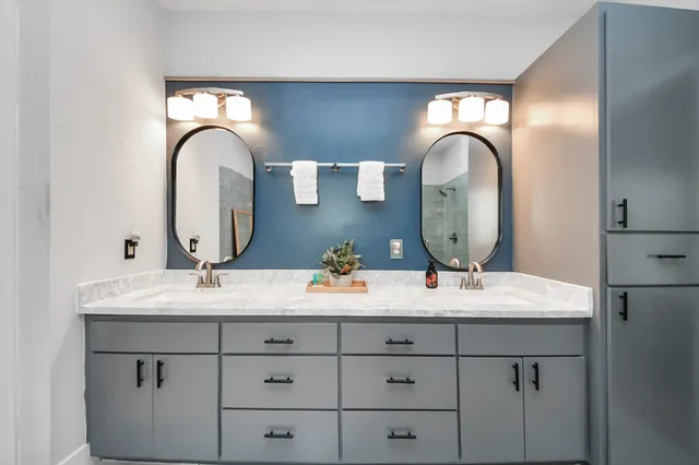 a bathroom with a double vanity sink and a mirror