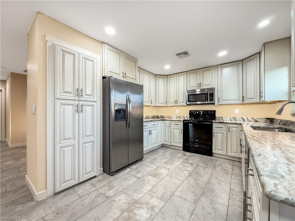2115 St Croix Avenue Fort Myers, FL 33905 - Photo 11 of 37 Kitchen featuring stainless steel appliances, light stone countertops, and recessed lighting