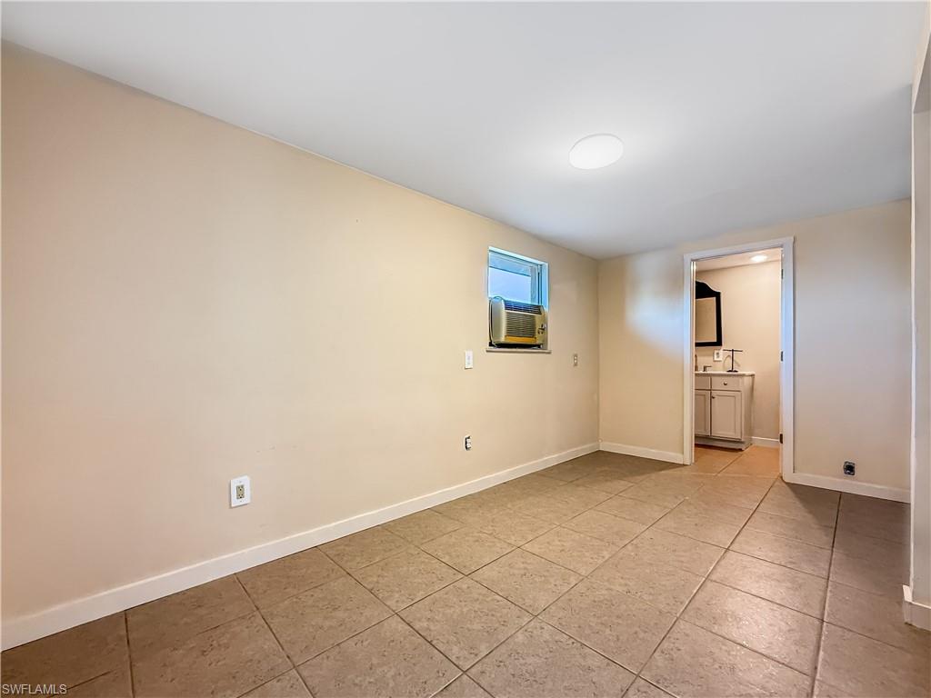 2115 St Croix Avenue Fort Myers, FL 33905 - Photo 22 of 37 Unfurnished bedroom with light tile patterned floors, cooling unit, and ensuite bath