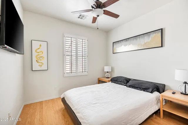 a bedroom with a bed and a flat tv screen on the dresser