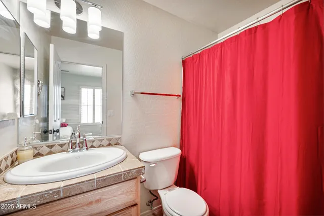 a bathroom with a toilet a sink and a mirror